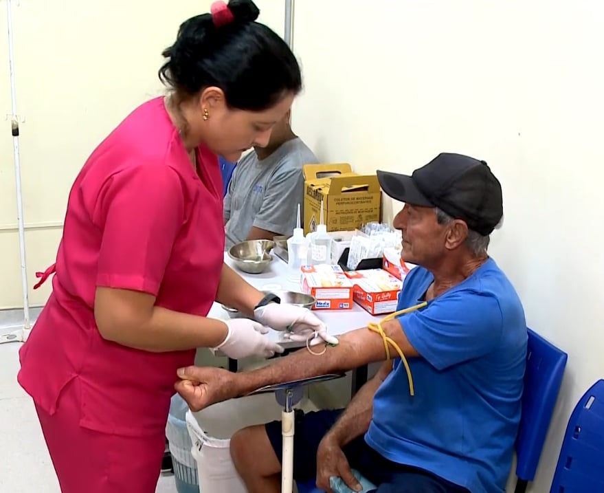 Enfermeira examinando paciente no núcleo de atendimento para dengue, em Votorantim.