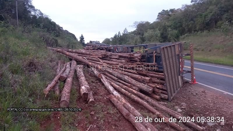 Carreta tomba e interdita rodovia Francisco Alves Negrão em Itapeva; carga de madeira aguarda remoção